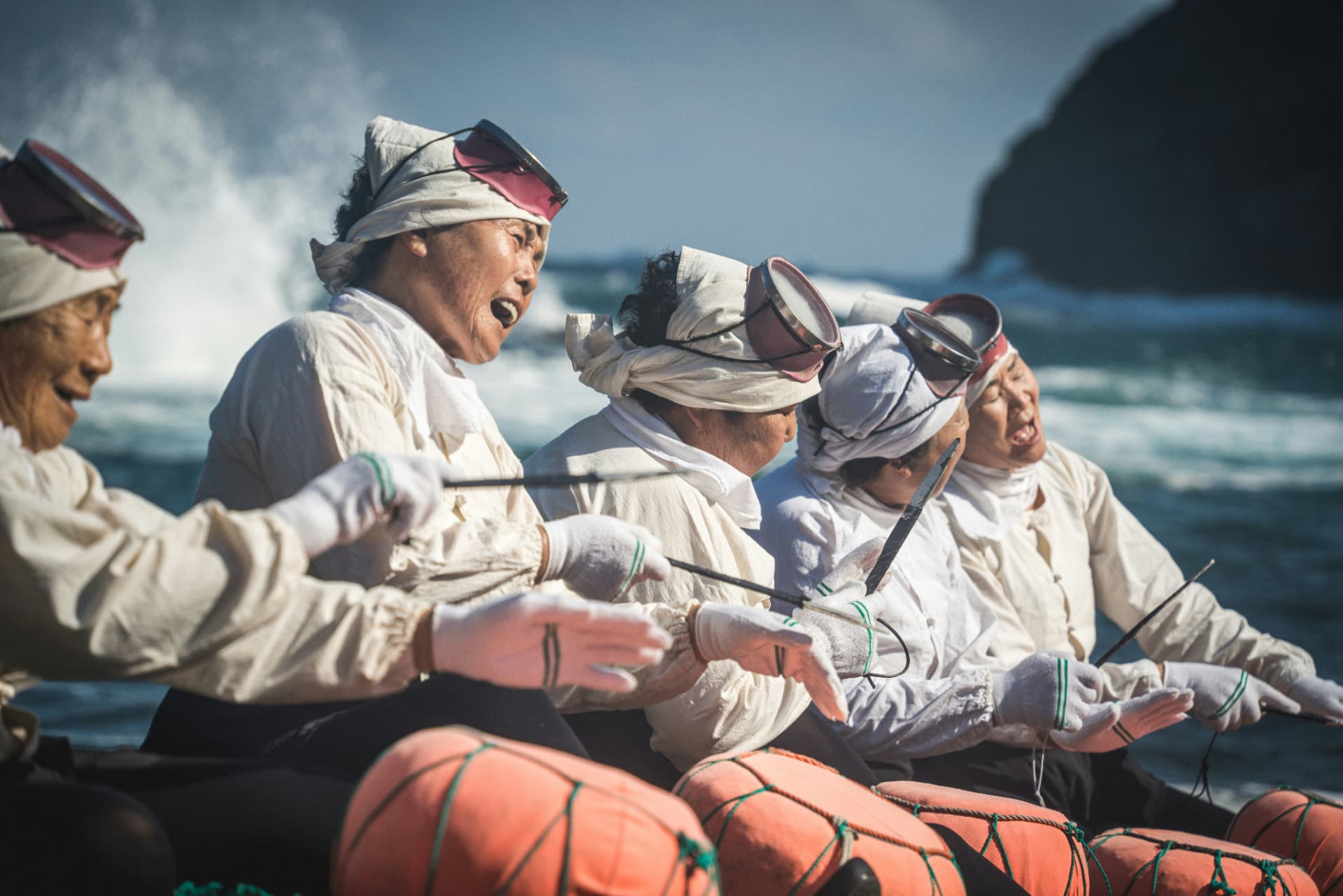Haenyeo divers singing together by the sea with their buoys
